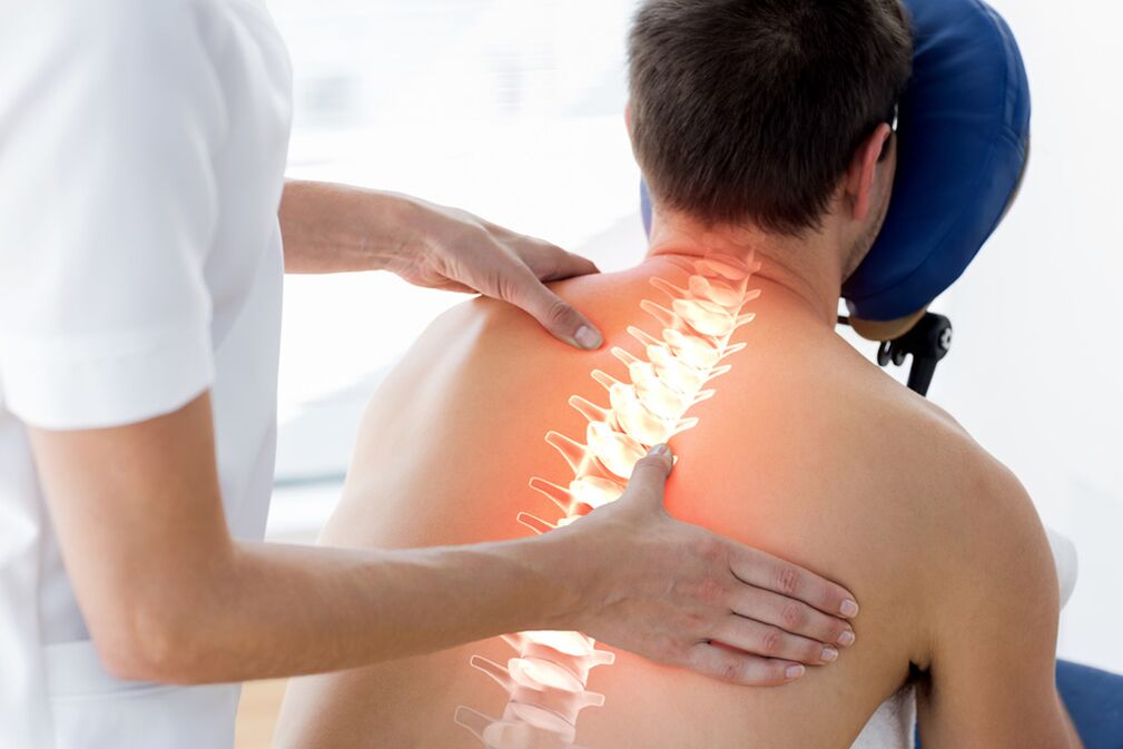 the doctor examines the back with thoracic osteochondrosis